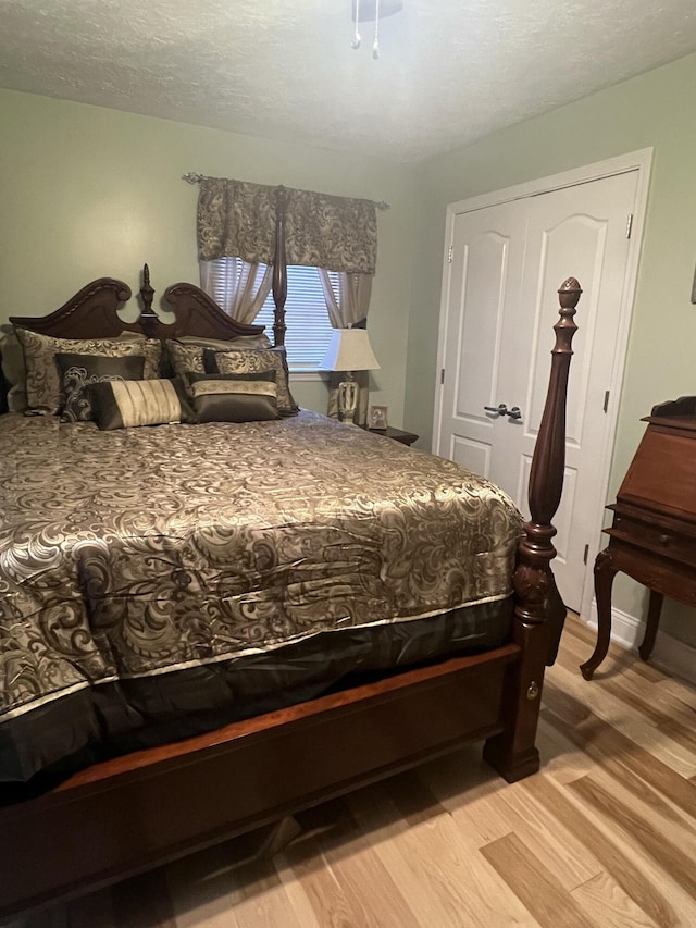 bedroom featuring light hardwood / wood-style floors and a textured ceiling