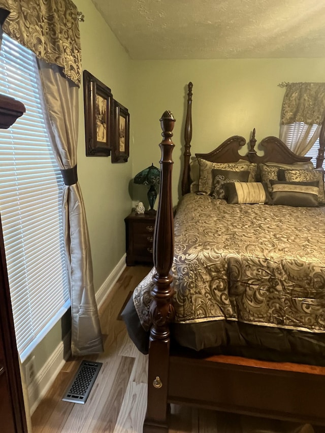 bedroom with wood-type flooring and a textured ceiling