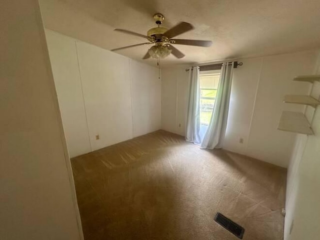 carpeted empty room featuring ceiling fan