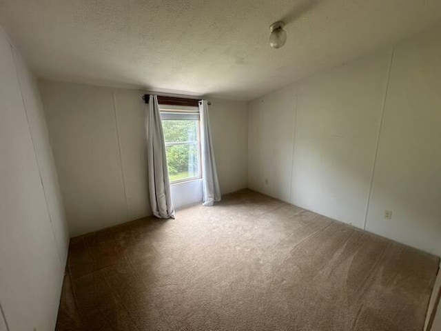 carpeted spare room featuring a textured ceiling