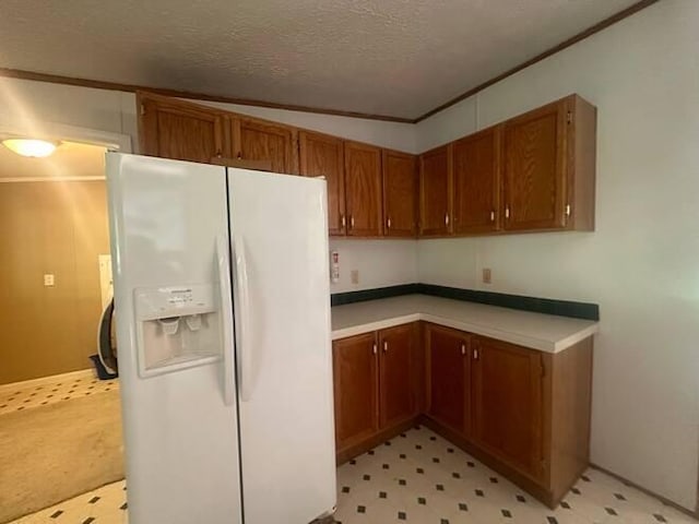 kitchen with lofted ceiling, white fridge with ice dispenser, a textured ceiling, and ornamental molding