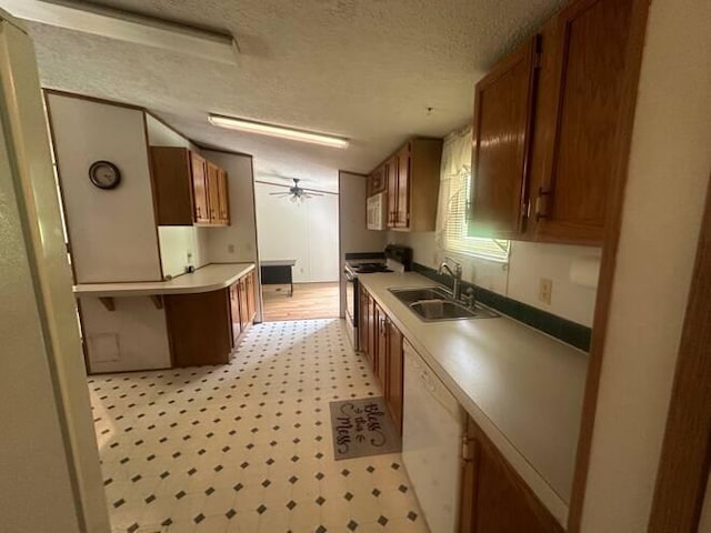 kitchen featuring a textured ceiling, ceiling fan, sink, and white appliances