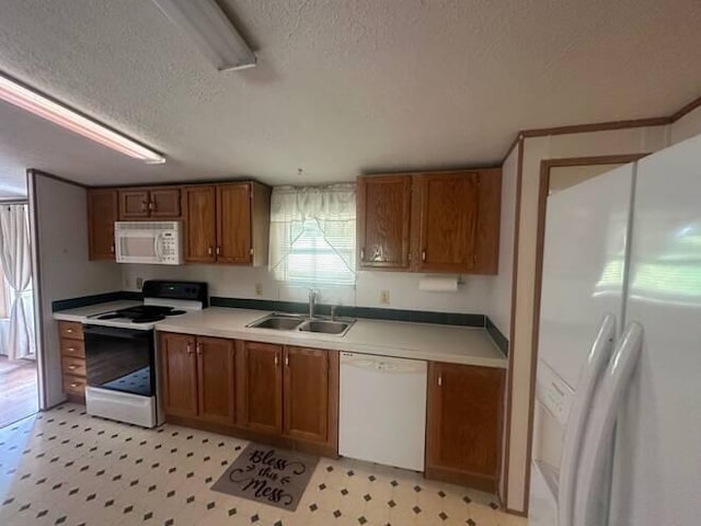 kitchen featuring a textured ceiling, sink, and white appliances