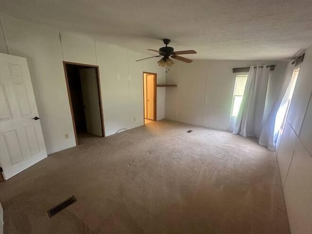 carpeted empty room featuring ceiling fan and a textured ceiling