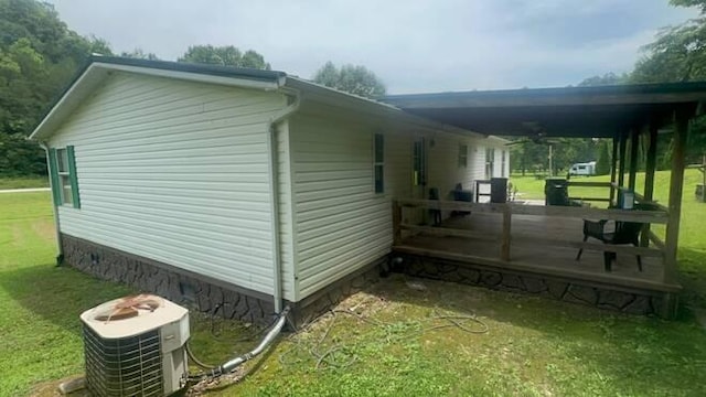 view of side of home featuring a lawn, ceiling fan, central AC unit, and a deck