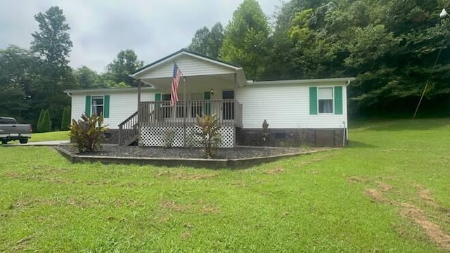 back of property featuring a yard and covered porch