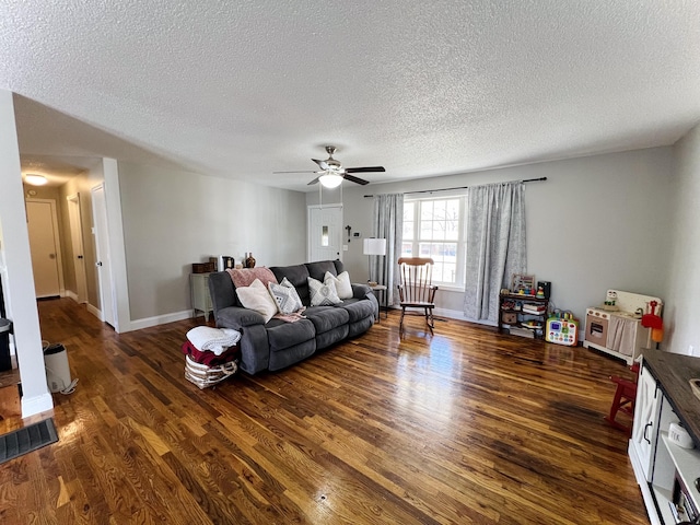 living room featuring a textured ceiling, dark hardwood / wood-style floors, and ceiling fan