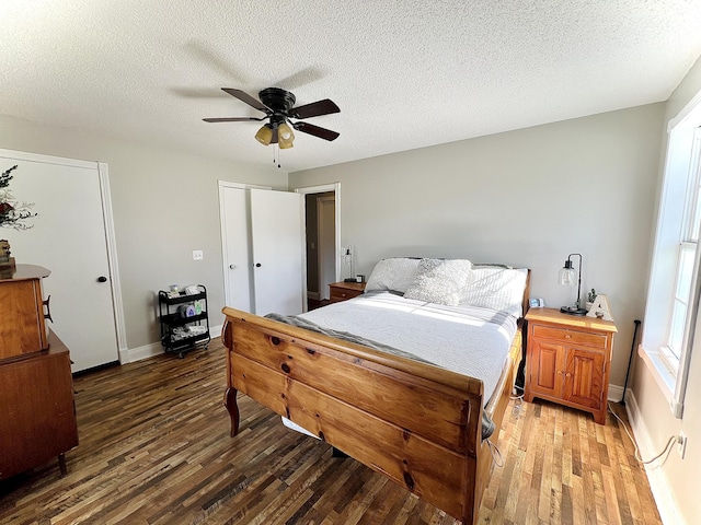 bedroom with ceiling fan, dark hardwood / wood-style flooring, and a textured ceiling