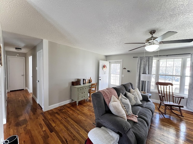 living room featuring ceiling fan, dark hardwood / wood-style flooring, and a textured ceiling