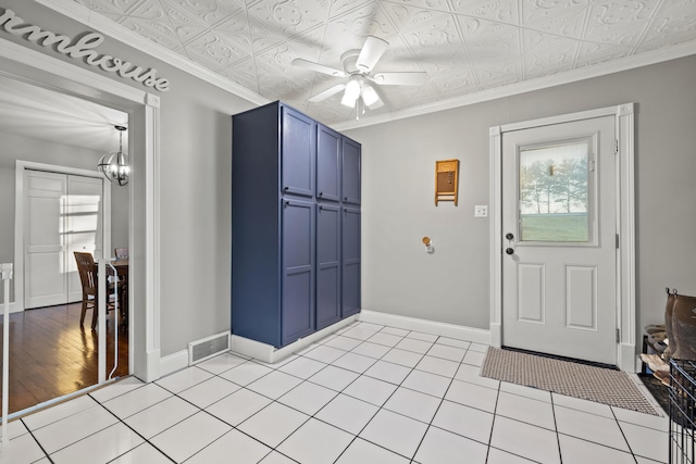 foyer featuring light tile patterned floors, ceiling fan with notable chandelier, and ornamental molding