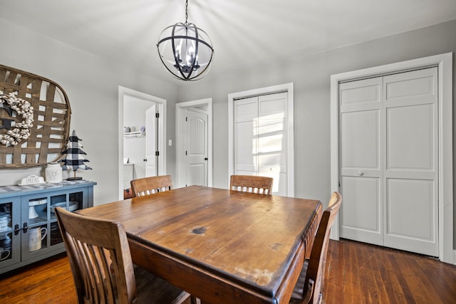 dining room featuring dark hardwood / wood-style flooring and an inviting chandelier