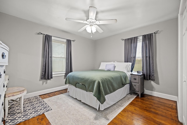 bedroom with dark hardwood / wood-style floors and ceiling fan