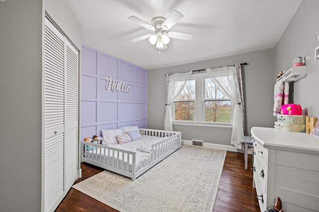 bedroom featuring ceiling fan, dark hardwood / wood-style floors, and a closet