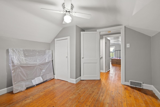 additional living space with ceiling fan, wood-type flooring, and vaulted ceiling