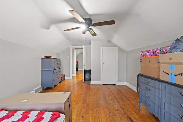 bedroom with ceiling fan, lofted ceiling, and light wood-type flooring