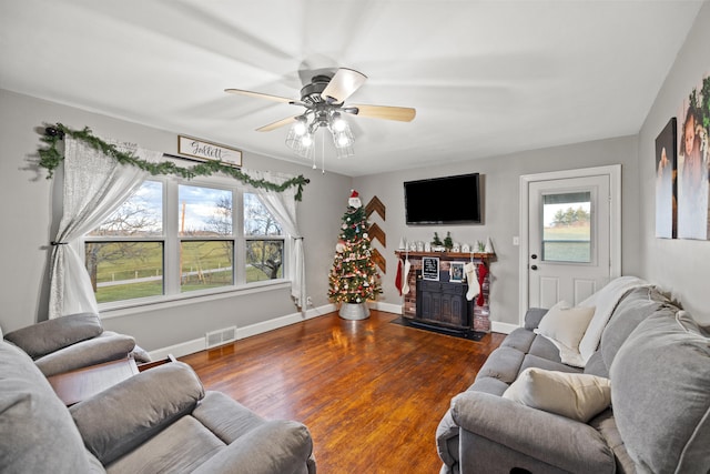 living room featuring ceiling fan, dark wood-type flooring, and a wealth of natural light