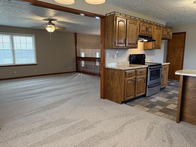 kitchen featuring stainless steel electric stove, ceiling fan, dark carpet, and a textured ceiling