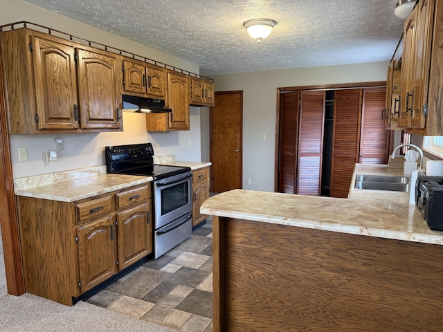 kitchen with a textured ceiling, sink, kitchen peninsula, and stainless steel range with electric cooktop