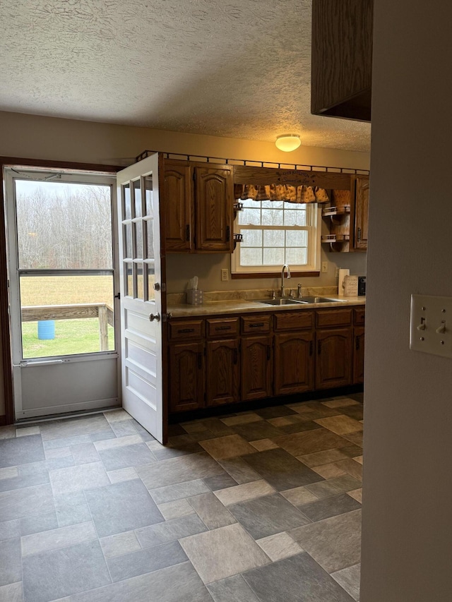 kitchen with plenty of natural light, a textured ceiling, and sink