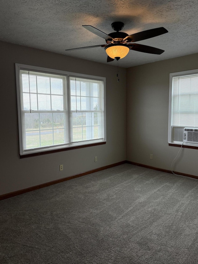 spare room featuring carpet flooring, ceiling fan, cooling unit, and a textured ceiling