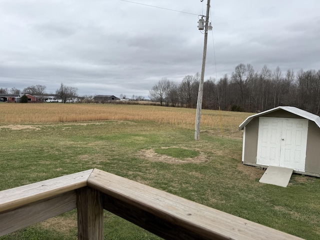 view of yard with a rural view and a storage shed