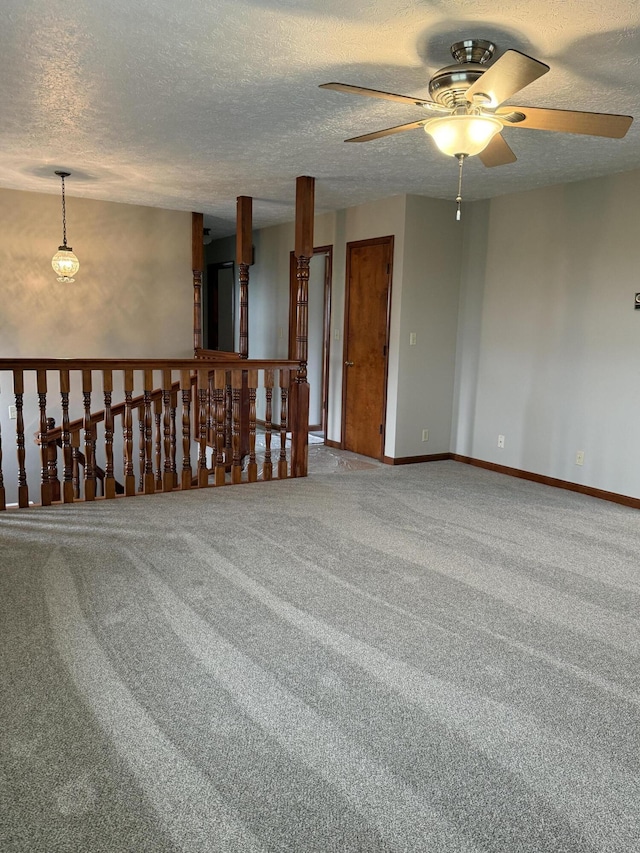 carpeted empty room with a textured ceiling and ceiling fan