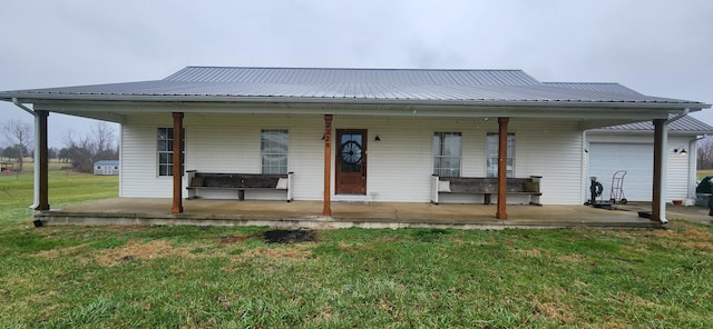 view of front of house featuring a garage, covered porch, and a front lawn