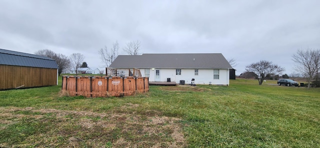 rear view of house featuring a yard and a pool side deck