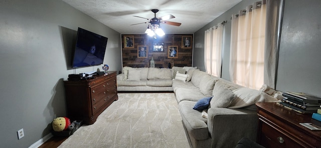 living room with ceiling fan and a textured ceiling