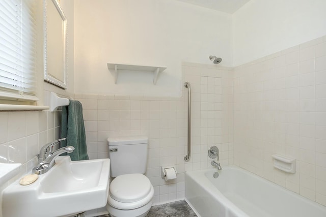 full bathroom featuring toilet, tile walls, tiled shower / bath combo, and sink