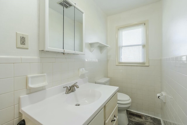 bathroom featuring tile walls, toilet, and vanity