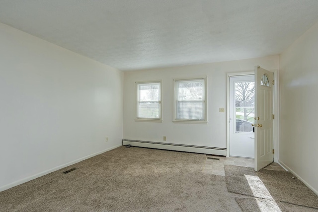 carpeted spare room with a baseboard radiator