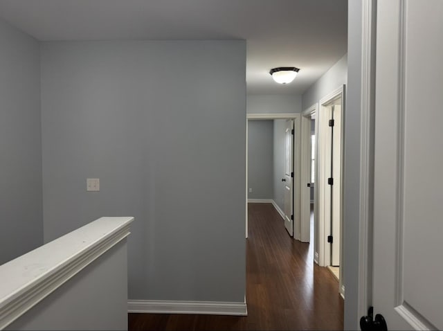 hall featuring baseboards and dark wood-style floors