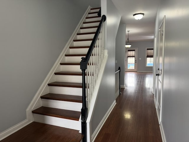 staircase featuring baseboards and wood finished floors