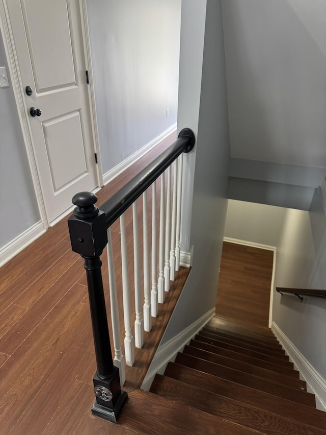 stairway featuring wood finished floors and baseboards