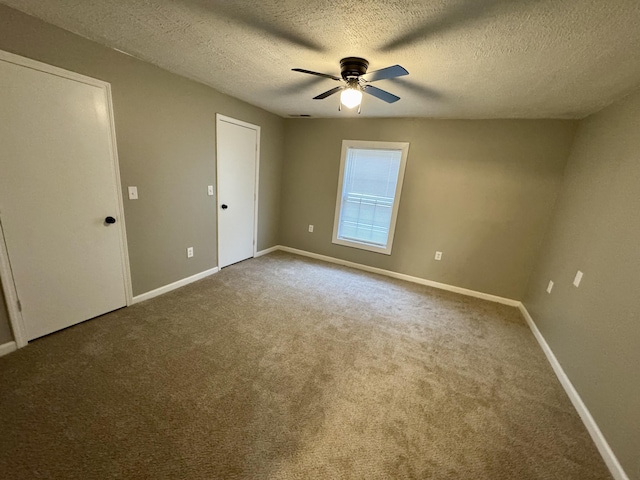 unfurnished bedroom with carpet, a textured ceiling, and ceiling fan