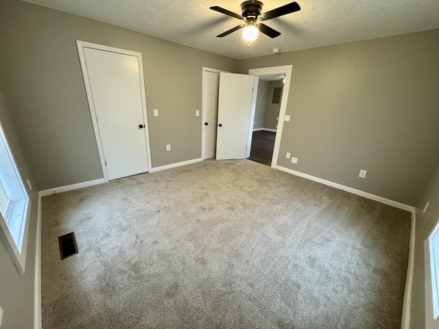 unfurnished bedroom with carpet, ceiling fan, and a textured ceiling