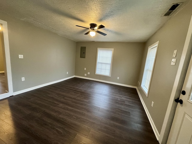 spare room featuring electric panel, ceiling fan, dark hardwood / wood-style flooring, and a textured ceiling