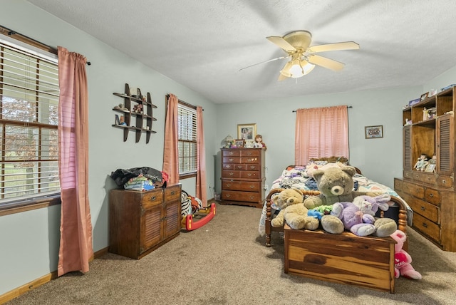 bedroom with ceiling fan, light colored carpet, and a textured ceiling