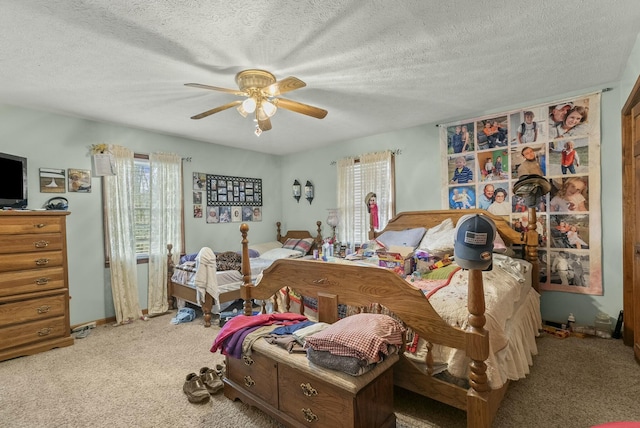 carpeted bedroom with ceiling fan and a textured ceiling