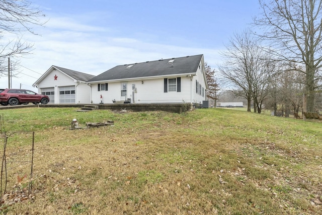 view of front of home with cooling unit, a front lawn, and a garage