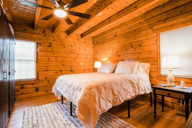 bedroom with ceiling fan, beam ceiling, wooden ceiling, and light hardwood / wood-style flooring