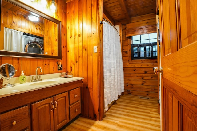 bathroom featuring vanity, wood walls, wooden ceiling, washer / dryer, and wood-type flooring