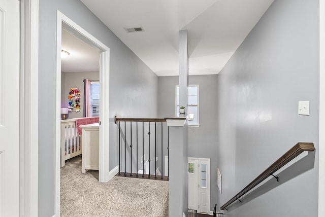 hallway with light colored carpet and plenty of natural light