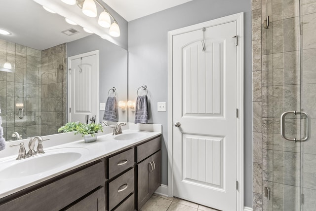 bathroom with tile patterned floors, vanity, and a shower with shower door