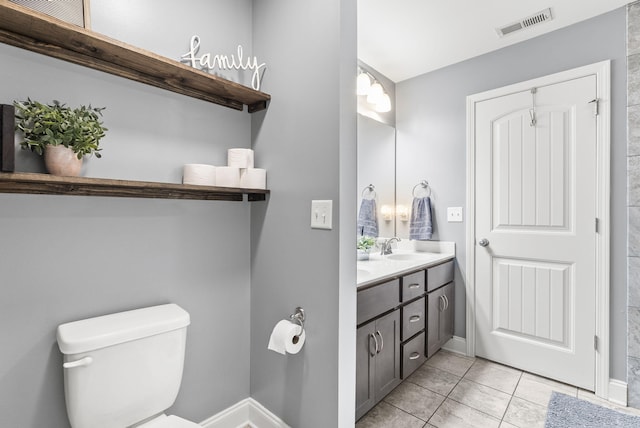 bathroom with tile patterned flooring, vanity, and toilet