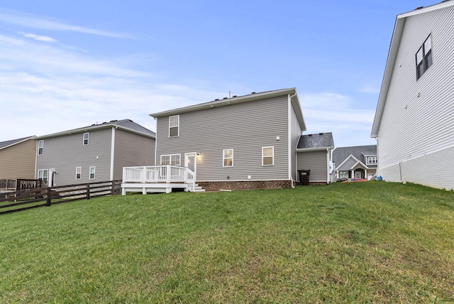 rear view of house with a deck and a lawn