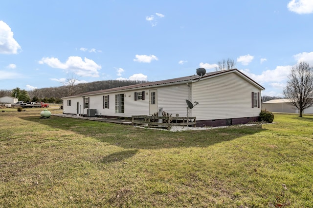 back of house featuring central AC and a lawn