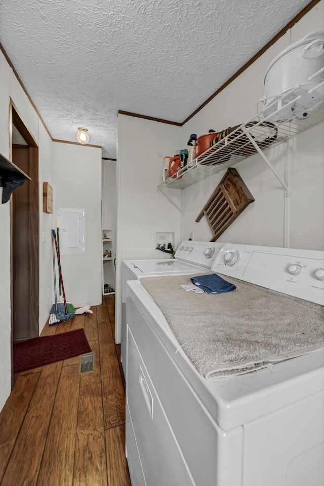 laundry room with a textured ceiling, washing machine and dryer, dark hardwood / wood-style floors, and ornamental molding