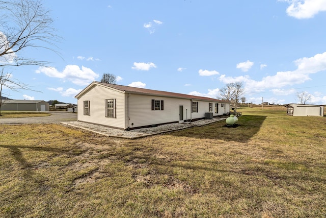 view of side of home featuring a lawn and central AC